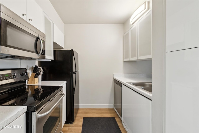 7625 E Camelback Rd Unit B226, Scottsdale, AZ 85251 - kitchen featuring stainless steel appliances, white cabinetry, light wood-type flooring, and light countertops