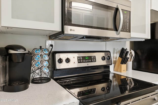 7625 E Camelback Rd Unit B226, Scottsdale, AZ 85251 - kitchen with stainless steel appliances, white cabinets, light countertops, and glass insert cabinets