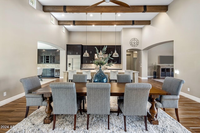 dining space with beamed ceiling, ceiling fan, dark hardwood / wood-style floors, and beverage cooler