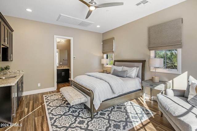 bedroom with ceiling fan, ensuite bathroom, and sink