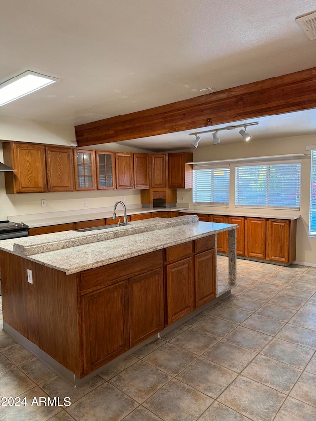 kitchen featuring light stone counters, tile flooring, electric range, a center island, and beam ceiling