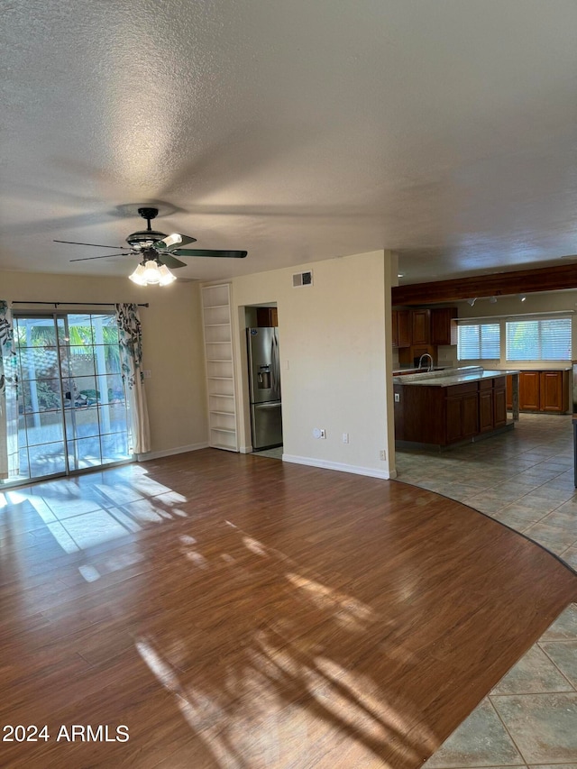 unfurnished living room with plenty of natural light, hardwood / wood-style flooring, and ceiling fan