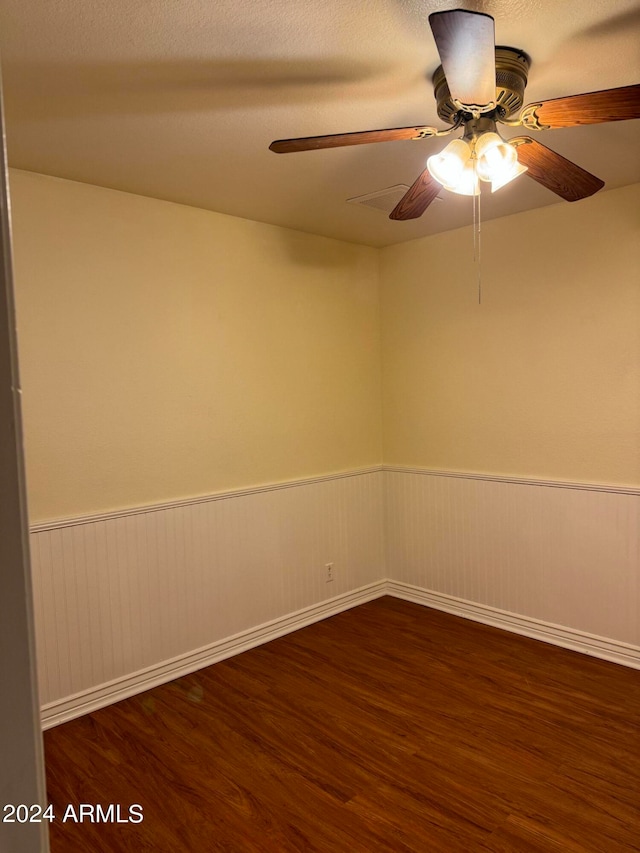 empty room with dark hardwood / wood-style floors and ceiling fan