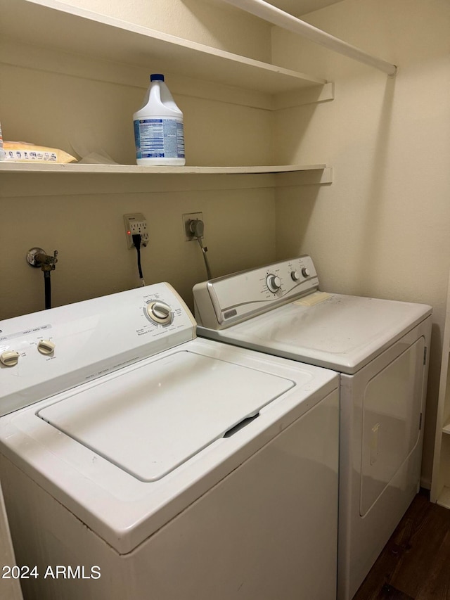 clothes washing area with washing machine and dryer, dark hardwood / wood-style flooring, and hookup for an electric dryer