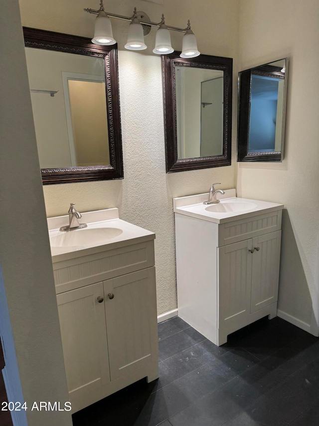 bathroom featuring oversized vanity, dual sinks, and tile floors