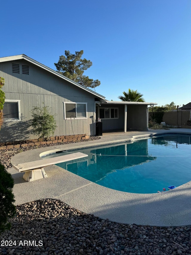 view of swimming pool featuring a diving board and a patio area