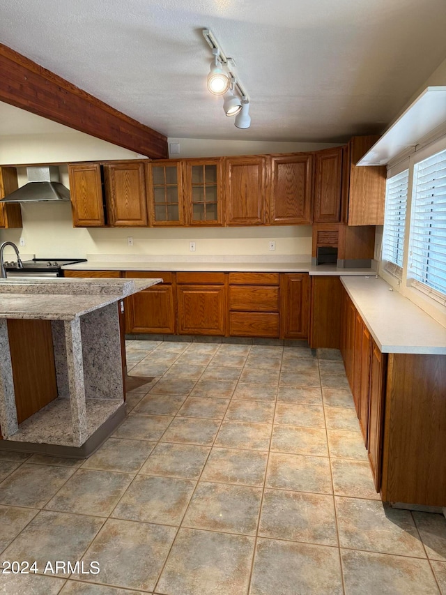 kitchen with electric range, a textured ceiling, track lighting, light tile floors, and wall chimney exhaust hood