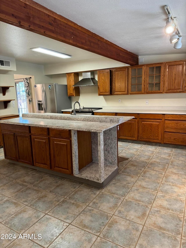 kitchen featuring appliances with stainless steel finishes, a textured ceiling, and wall chimney exhaust hood