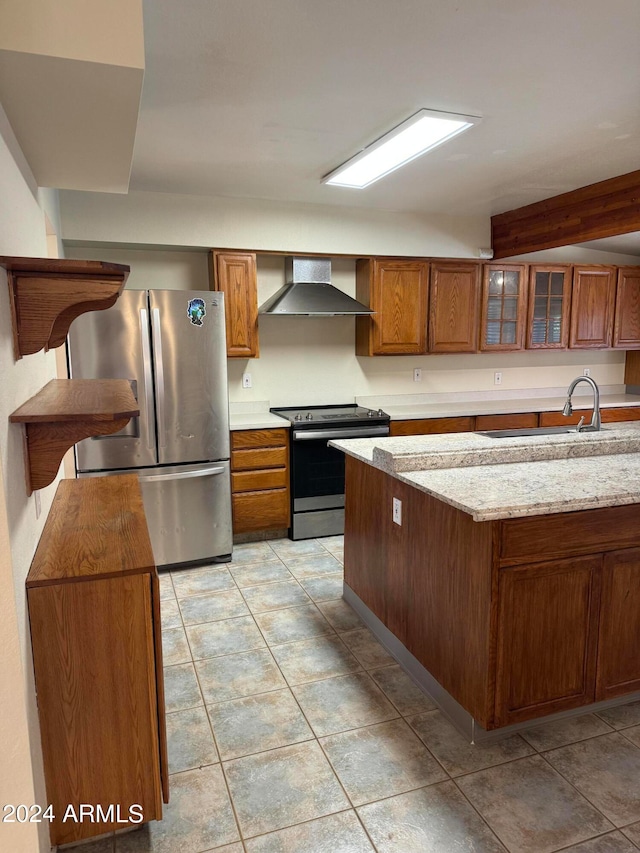 kitchen featuring light stone counters, stainless steel appliances, wall chimney exhaust hood, sink, and light tile floors