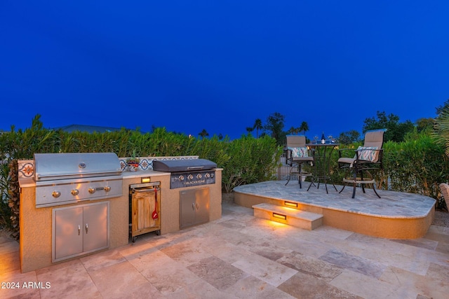 patio at night featuring area for grilling