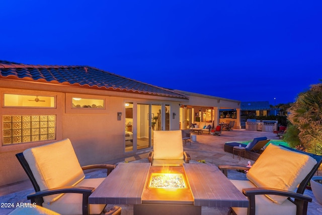 patio at twilight with area for grilling and a fire pit