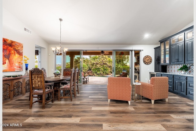 dining room with vaulted ceiling, dark wood-type flooring, and a chandelier