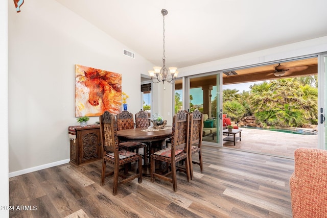 dining room featuring a chandelier, dark wood-type flooring, and lofted ceiling