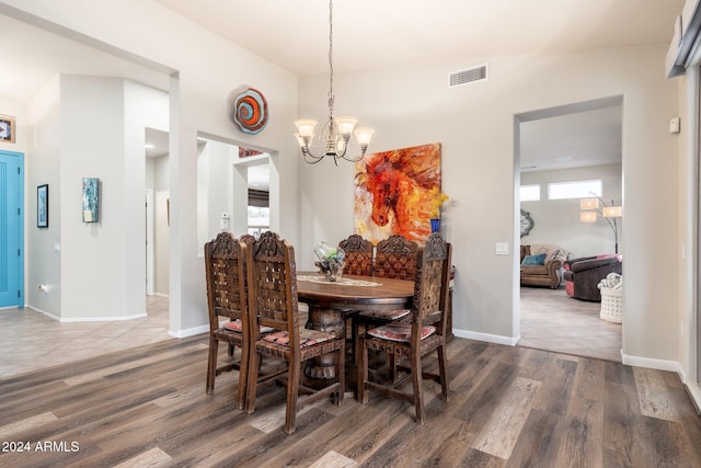 dining space featuring wood-type flooring and a notable chandelier