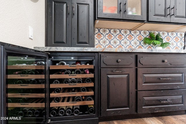 bar with beverage cooler and light hardwood / wood-style flooring