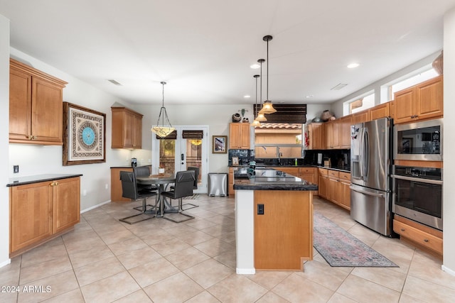 kitchen featuring stainless steel appliances, a kitchen island, hanging light fixtures, and sink