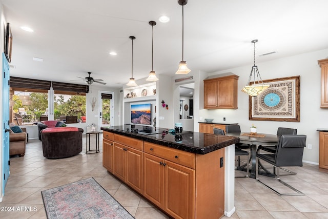 kitchen with black electric stovetop, ceiling fan, light tile patterned floors, a center island, and hanging light fixtures