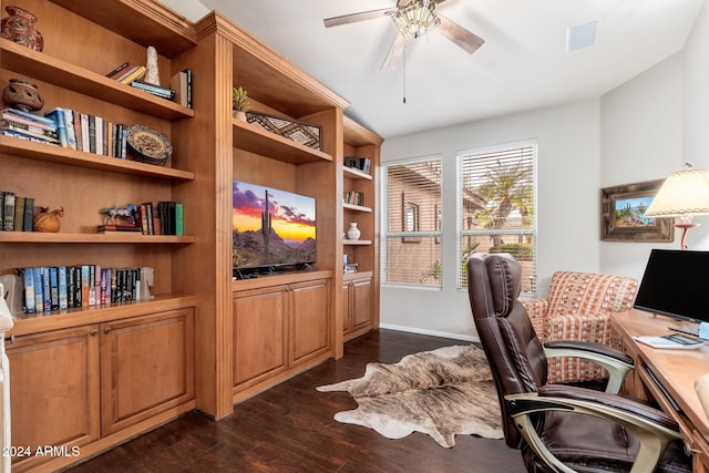 home office featuring built in shelves, ceiling fan, and dark wood-type flooring