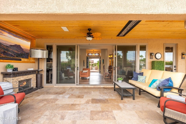 view of patio with an outdoor living space with a fireplace and ceiling fan