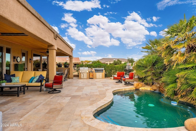 view of swimming pool with an outdoor living space, a patio, a grill, and exterior kitchen