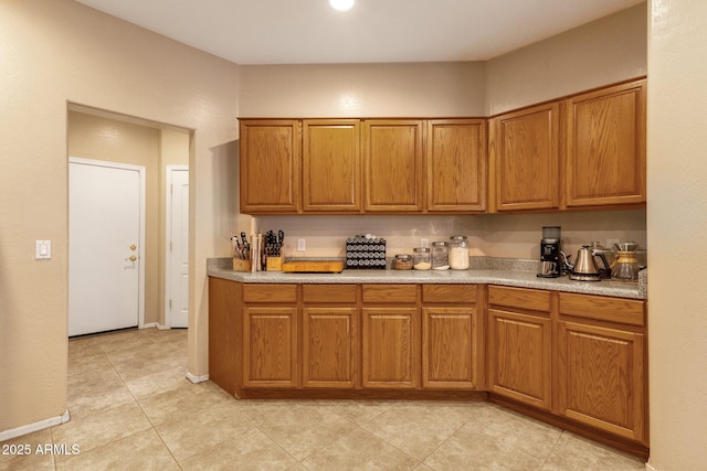 kitchen featuring light countertops, brown cabinets, and baseboards