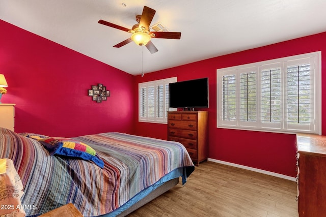 bedroom with a ceiling fan, baseboards, and wood finished floors