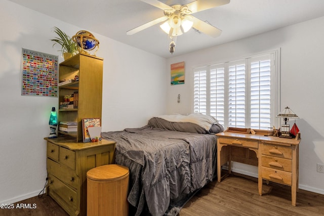 bedroom with a ceiling fan, baseboards, and wood finished floors