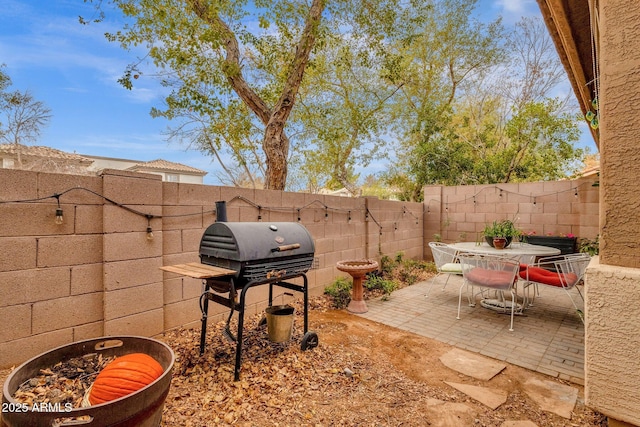 view of patio / terrace featuring outdoor dining space, a fenced backyard, and a grill