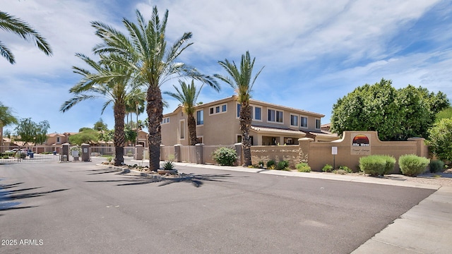 exterior space featuring a gate, sidewalks, curbs, and a gated entry