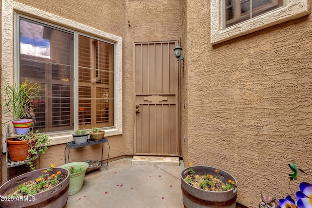 doorway to property featuring stucco siding