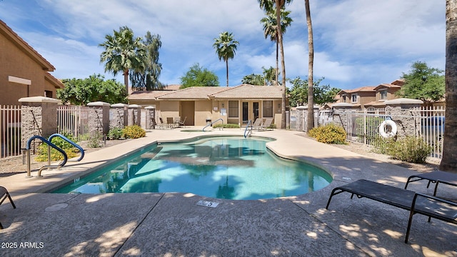 pool with a patio area and fence