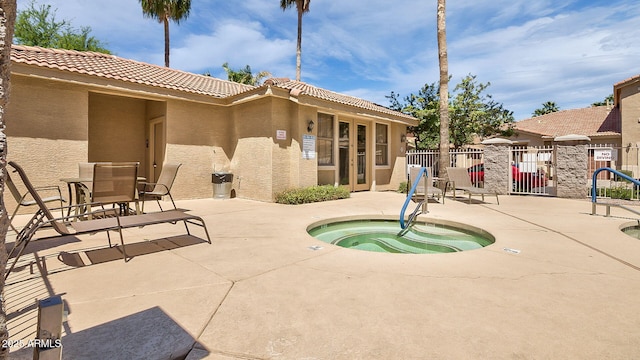 view of pool featuring a patio area, a hot tub, and fence