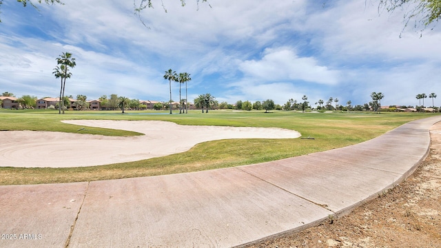 view of property's community with golf course view and a lawn