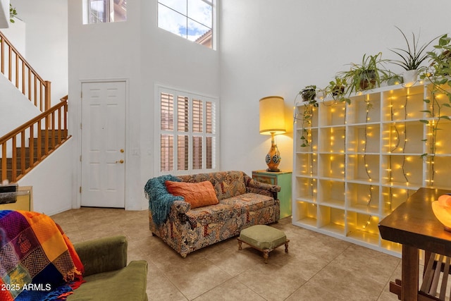 living room with tile patterned floors, a towering ceiling, and stairs