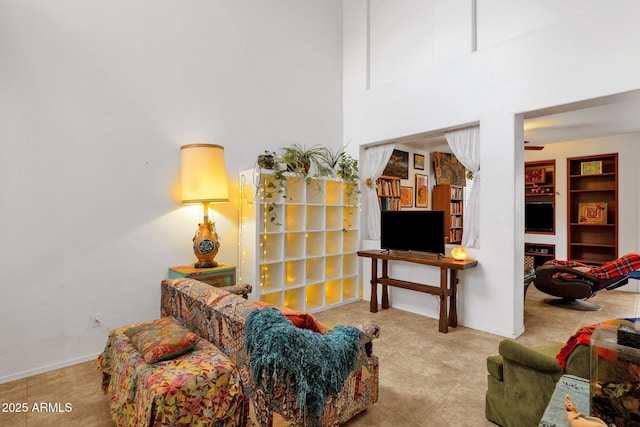 living room featuring tile patterned flooring, a towering ceiling, and baseboards