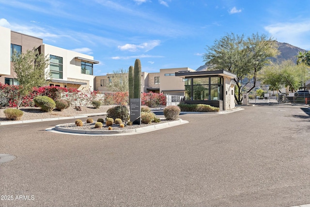 view of street featuring curbs, a gated entry, and a mountain view