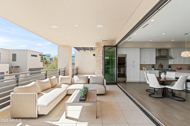 balcony with wine cooler, visible vents, and outdoor lounge area