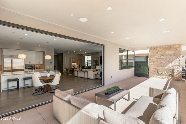 living room featuring light tile patterned floors, a stone fireplace, and recessed lighting