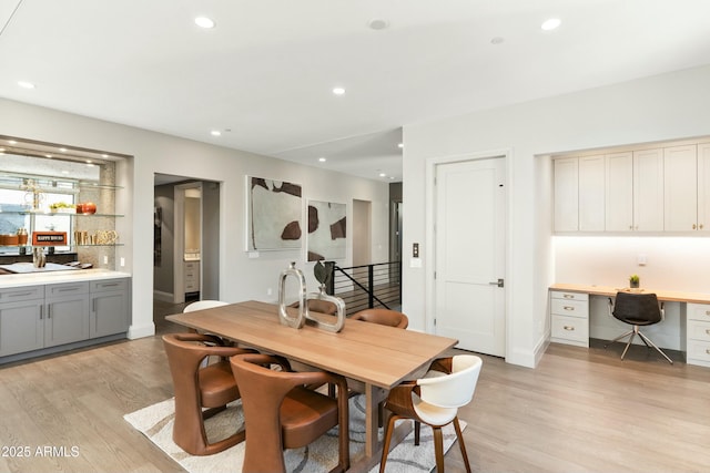 dining area with light wood-type flooring, recessed lighting, baseboards, and built in study area