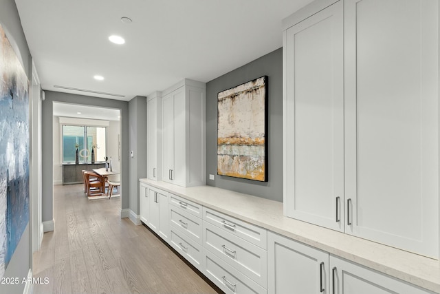 hallway featuring light wood-style floors, recessed lighting, and baseboards