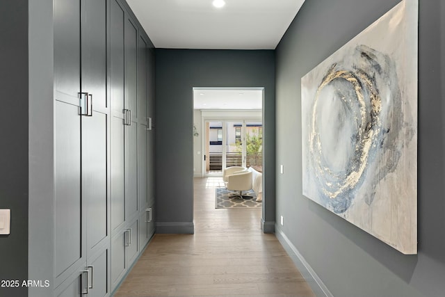 hall with baseboards and light wood-style floors