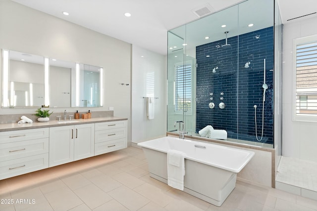 bathroom with a stall shower, a soaking tub, tile patterned flooring, and vanity