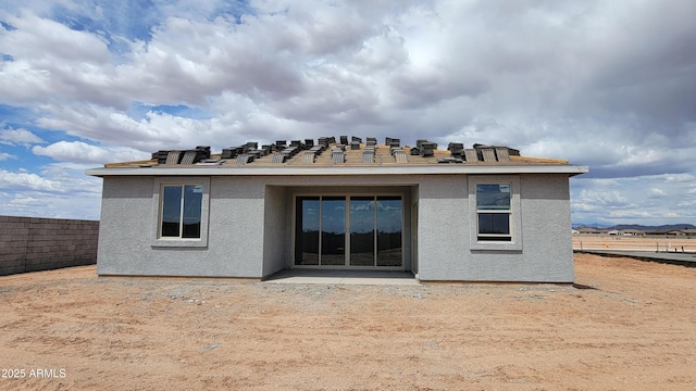 back of property with fence and stucco siding