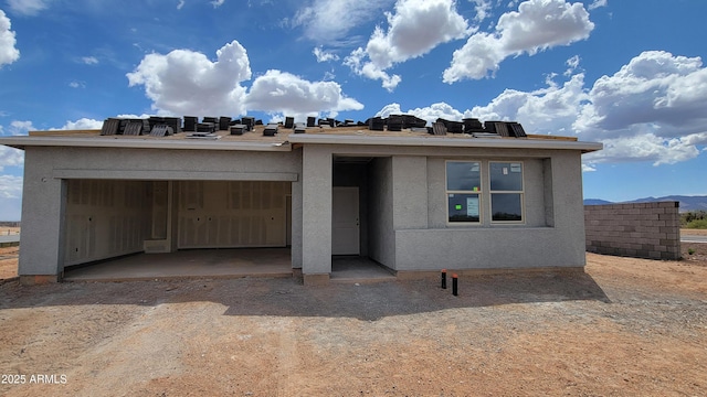 property under construction with a garage and stucco siding