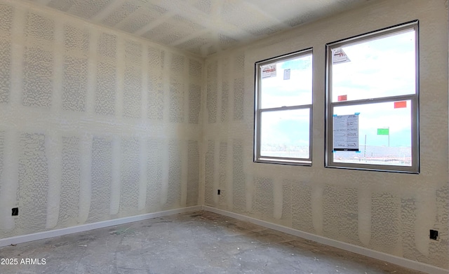 spare room with baseboards and a healthy amount of sunlight