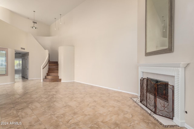 unfurnished living room with high vaulted ceiling