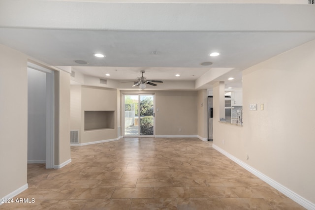 unfurnished living room featuring ceiling fan