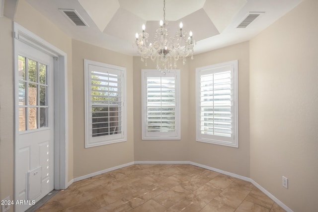 unfurnished dining area featuring a wealth of natural light and an inviting chandelier