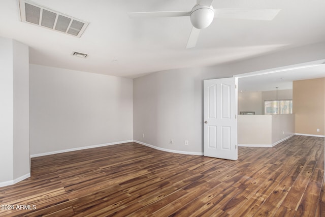 empty room with ceiling fan and dark hardwood / wood-style flooring