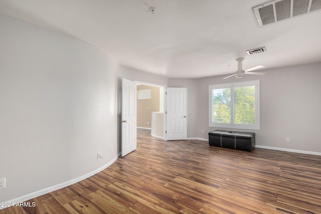 spare room with dark hardwood / wood-style floors and ceiling fan